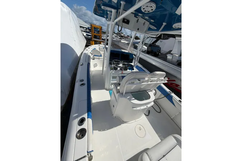 Slide: The Image of 2015 Sea Hunt Gamefish 25 boat interior with helm and seating, docked under blue sky. - 9