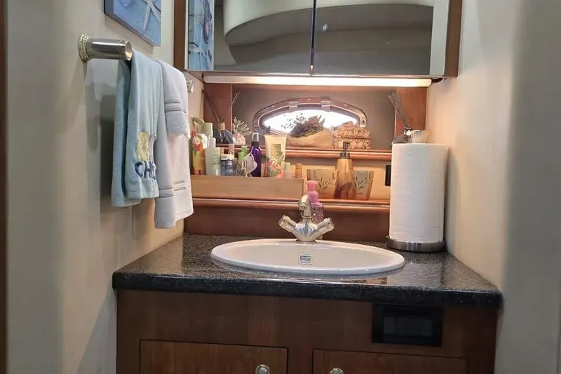 Slide: The Image of Luxurious 2005 Cruisers Yachts 440 Express bathroom with sink and toiletries. - 18