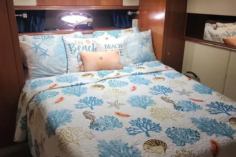 Slide: The Image of Cozy bedroom in 2005 Cruisers Yachts 440 Express with nautical-themed bedding. - 13