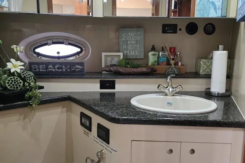 Slide: The Image of 2005 Cruisers Yachts 440 Express bathroom with sink, decor, and porthole window. - 17