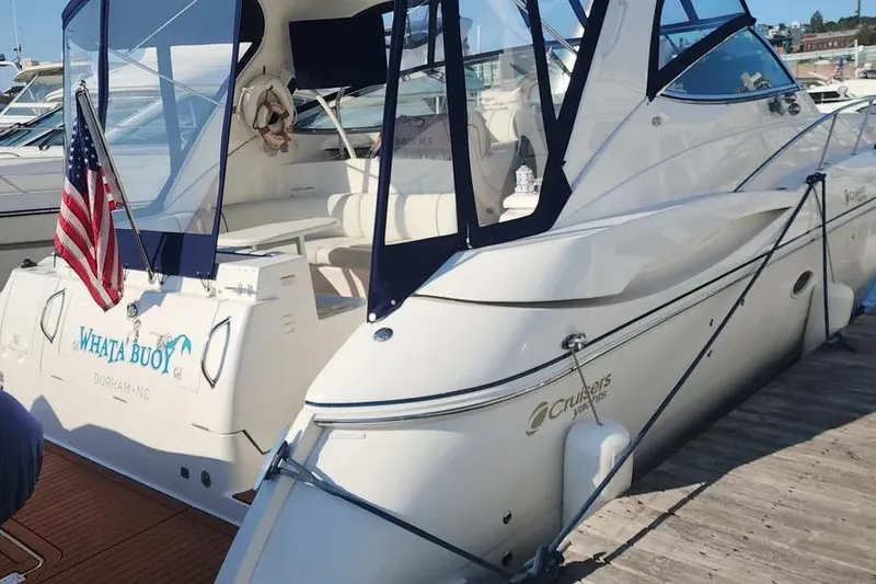 Slide: The Image of 2005 Cruisers Yachts 440 Express docked with American flag and custom name. - 2