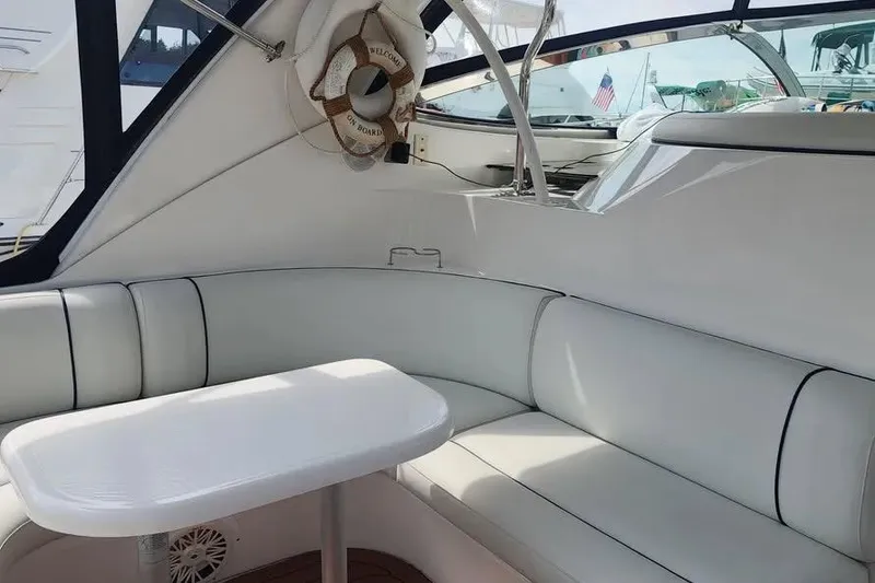 Slide: The Image of 2005 Cruisers Yachts 440 Express interior with white seating and table. - 6