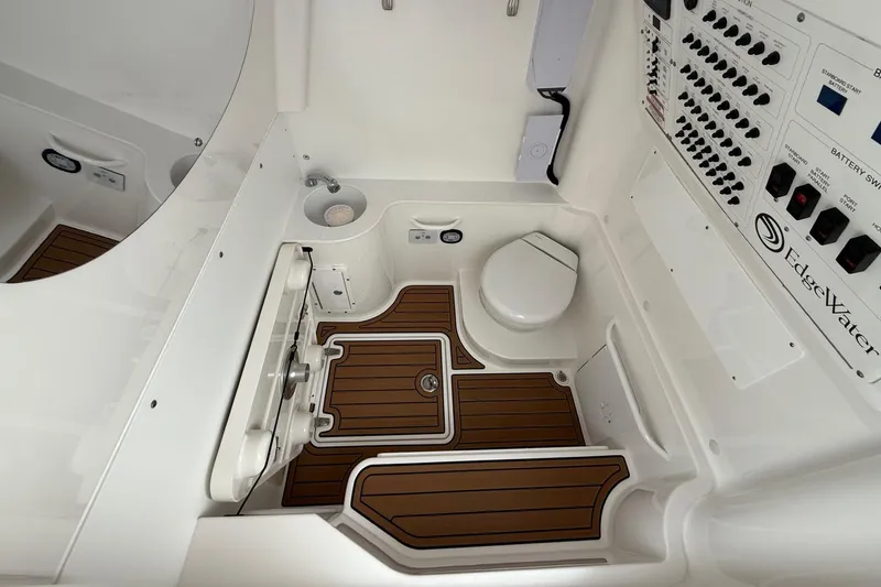 Slide: The Image of 2023 Edgewater 340CC boat interior with control panel and compact bathroom. - 12