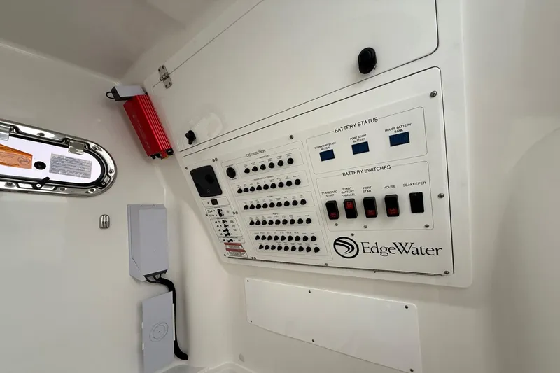 Slide: The Image of Control panel of 2023 Edgewater 340CC boat, featuring battery status and switches. - 13