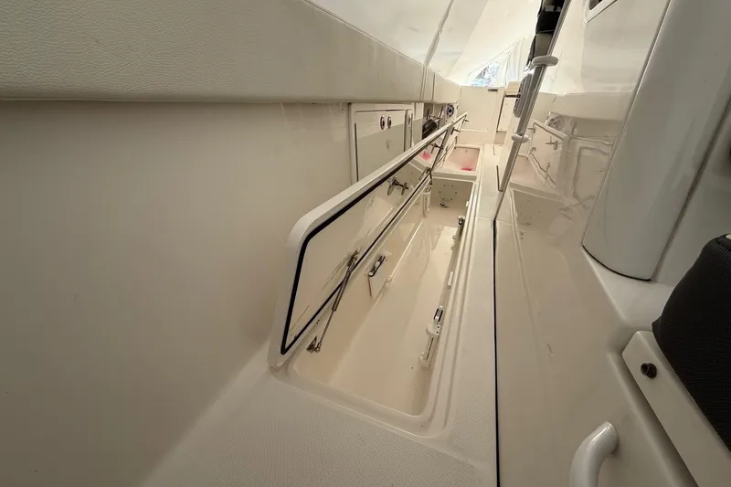 Slide: The Image of 2023 Edgewater 340CC boat interior with open storage compartments. - 14