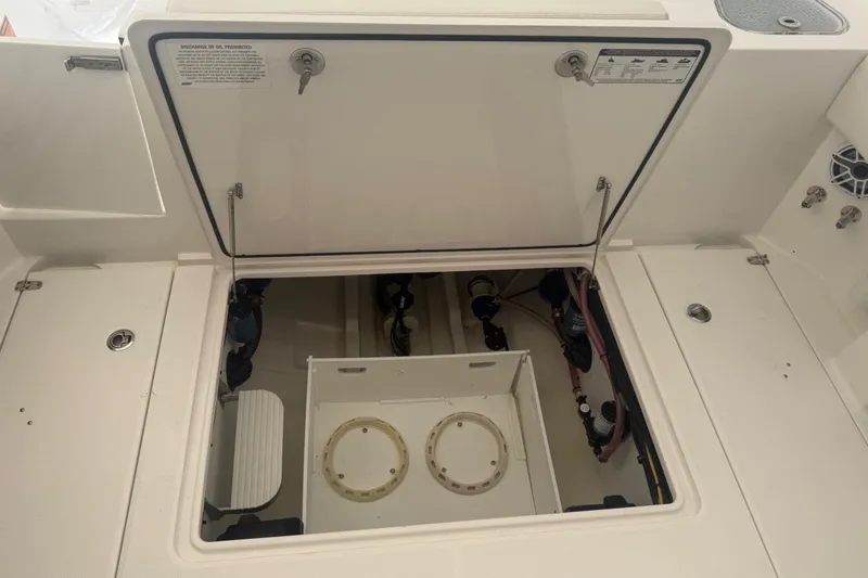 Slide: The Image of 2023 Edgewater 340CC boat storage compartment with open hatch, showcasing internal components. - 19