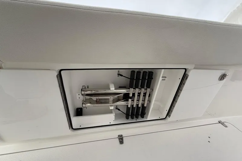 Slide: The Image of 2023 Edgewater 340CC boat storage compartment with organized rod holders. - 28