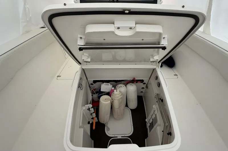 Slide: The Image of 2023 Edgewater 340CC boat storage compartment with safety equipment and supplies. - 9