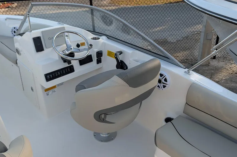 Slide: The Image of 2026 Key West 203 DFS boat interior with steering wheel and seating. - 11