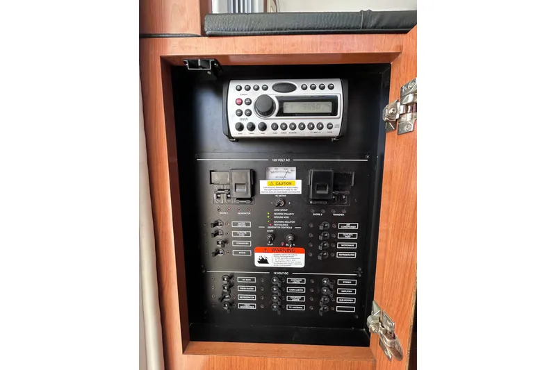 Slide: The Image of Electrical control panel of a 2006 Wellcraft 290 Coastal boat, featuring various switches and a radio. - 15