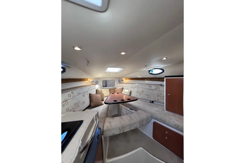 Slide: The Image of 2006 Wellcraft 290 Coastal cabin interior with seating and table, featuring modern design. - 16
