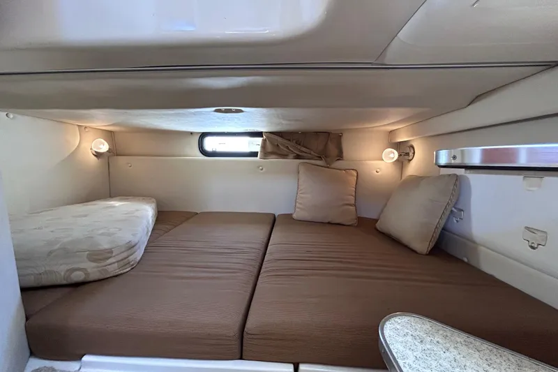 Slide: The Image of 2006 Wellcraft 290 Coastal cabin interior with cozy bedding and ambient lighting. - 19