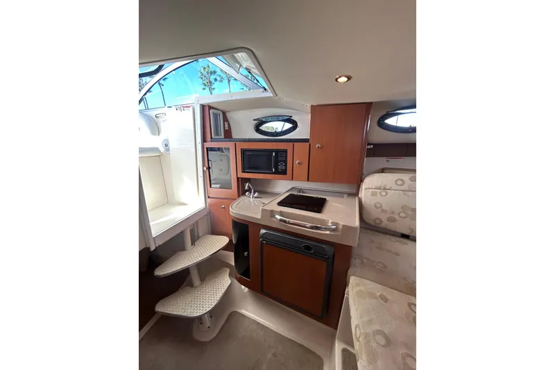 Slide: The Image of Interior of 2006 Wellcraft 290 Coastal boat, featuring kitchenette and seating area. - 23