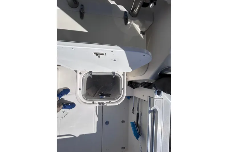 Slide: The Image of 2006 Wellcraft 290 Coastal boat interior with storage compartment and cleaning tools. - 33