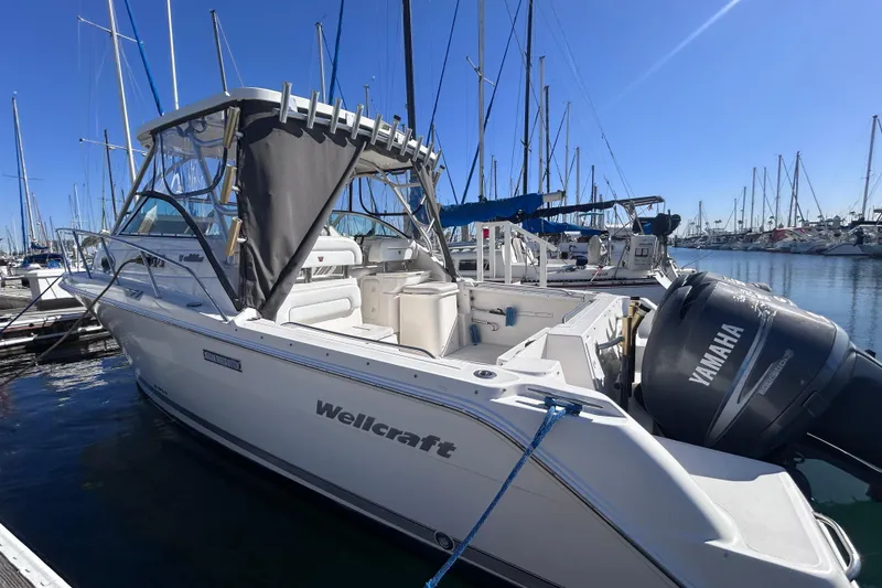 Slide: The Image of 2006 Wellcraft 290 Coastal boat docked, featuring Yamaha outboard motor, clear blue sky. - 9