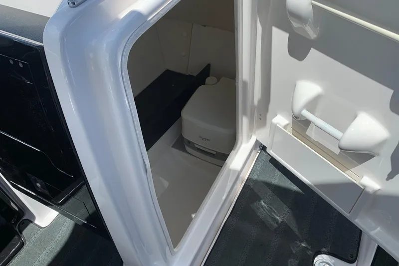 Slide: The Image of Interior view of a 2016 Yamaha Boats 242 Limited, featuring a compact onboard toilet. - 8