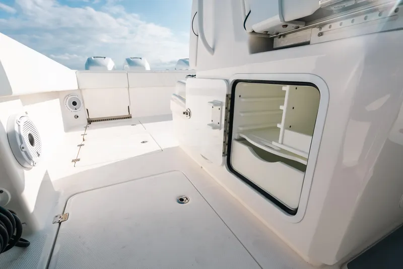 Slide: The Image of 2021 Invincible 37 Catamaran deck with storage compartment and seating, under a clear sky. - 38