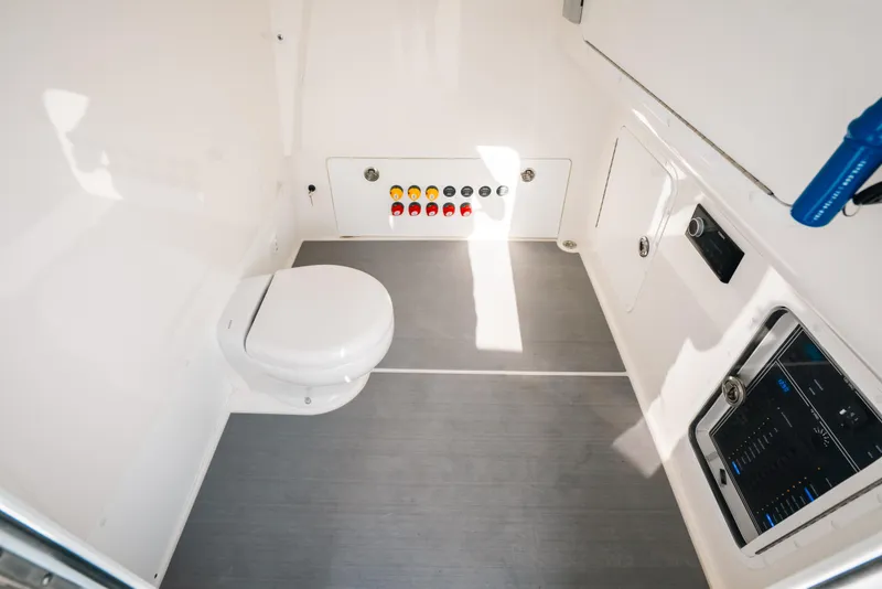 Slide: The Image of Interior of 2021 Invincible 37 Catamaran featuring a compact marine toilet and control panel. - 44
