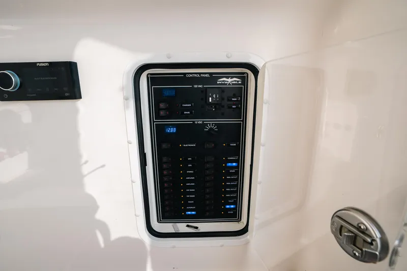 Slide: The Image of Control panel of 2021 Invincible 37 Catamaran, featuring various switches and displays. - 46