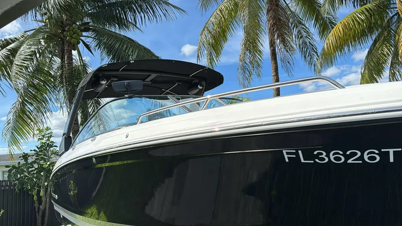 Slide: The Image of 2021 Chaparral 30 Surf boat under palm trees with blue sky background. - 6