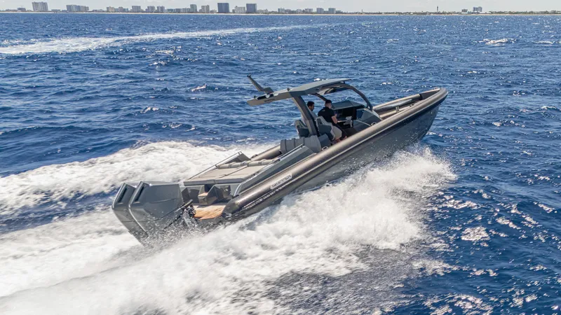 Slide: The Image of 2025 Skipper-BSK 38 boat cruising on open sea with city skyline in background. - 16