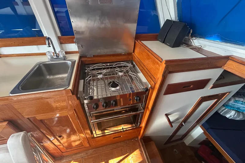 Slide: The Image of Interior of 1973 Grand Banks 32 Sedan with blue seating and wooden cabinetry. - 11