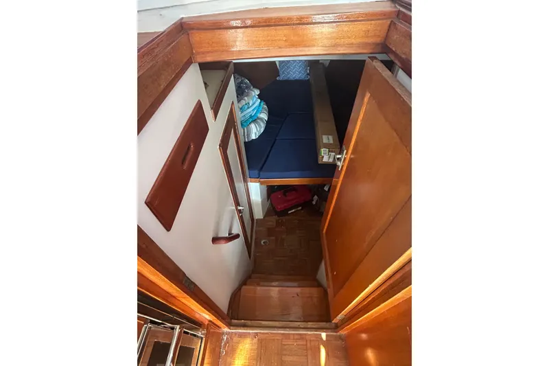 Slide: The Image of 1973 Grand Banks 32 Sedan interior view, showcasing helm and marina backdrop. - 18