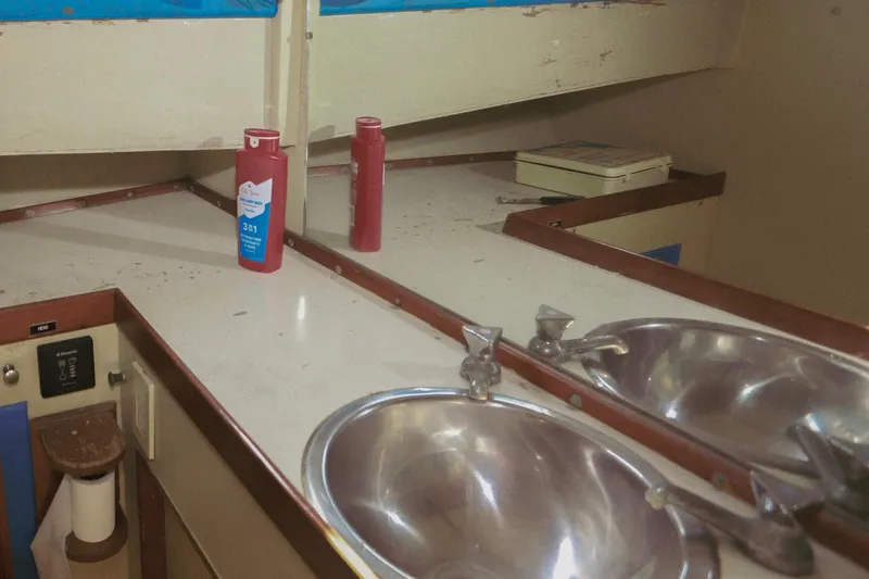 Slide: The Image of 1973 Grand Banks 32 Sedan bathroom with sink, mirror, and toiletries. - 30