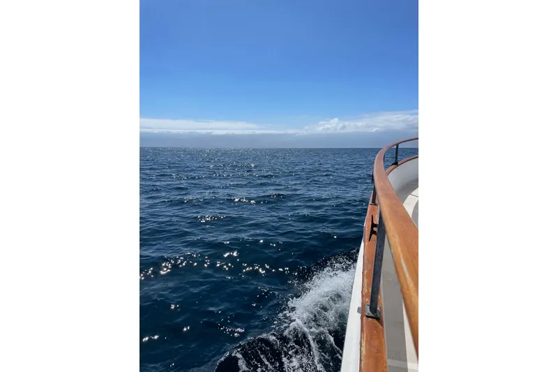 Slide: The Image of 1973 Grand Banks 32 Sedan cruising on open sea under clear blue sky. - 33