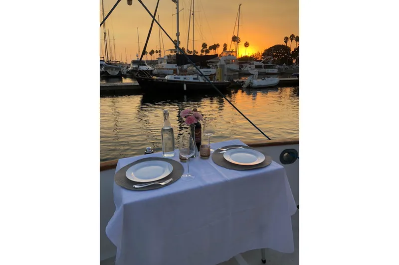 Slide: The Image of Romantic dinner setup on a 1973 Grand Banks 32 Sedan at sunset in a marina. - 34