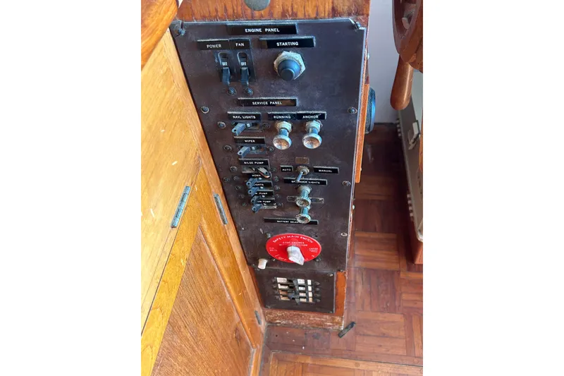 Slide: The Image of Control panel of a 1973 Grand Banks 32 Sedan boat with various switches and knobs. - 43