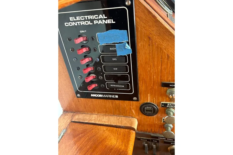 Slide: The Image of Electrical control panel on 1973 Grand Banks 32 Sedan boat with switches and labels. - 44