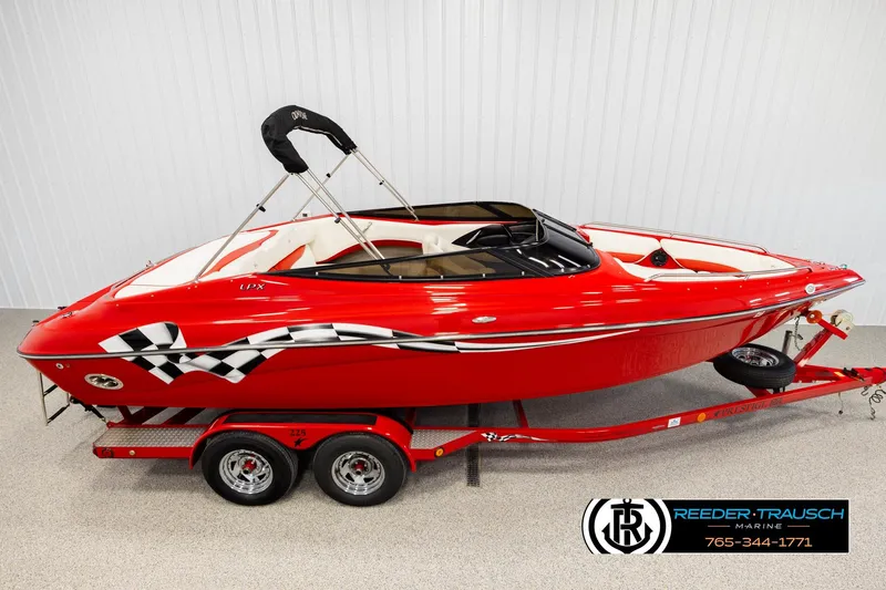 Slide: The Image of 2005 Crownline 225 LPX red speedboat with checkered flag design on trailer. - 1