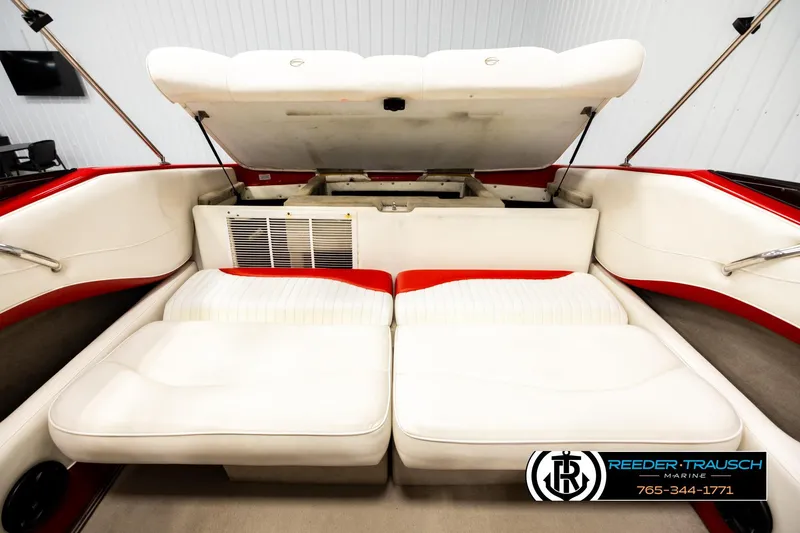 Slide: The Image of 2005 Crownline 225 LPX boat interior with white and red seating, open storage compartment. - 21