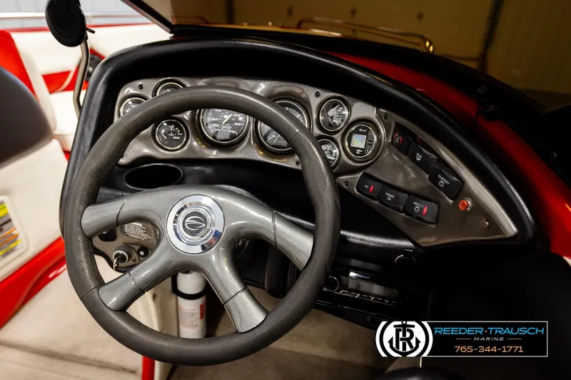 Slide: The Image of Steering wheel and dashboard of 2005 Crownline 225 LPX boat, featuring gauges and controls. - 23