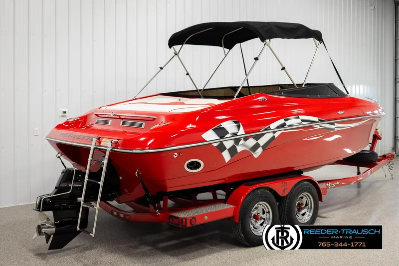 Slide: The Image of 2005 Crownline 225 LPX boat, red with checkered flag design, on trailer in showroom. - 6