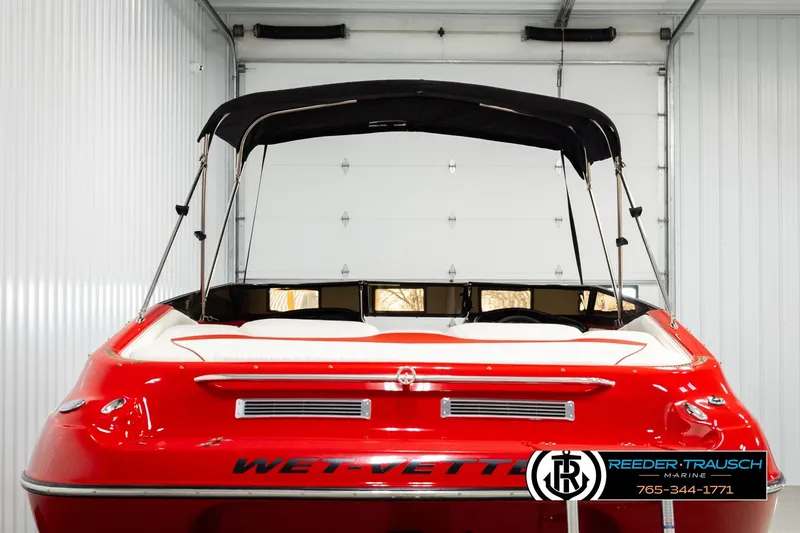 Slide: The Image of 2005 Crownline 225 LPX boat, red exterior, in a garage with a black canopy. - 7