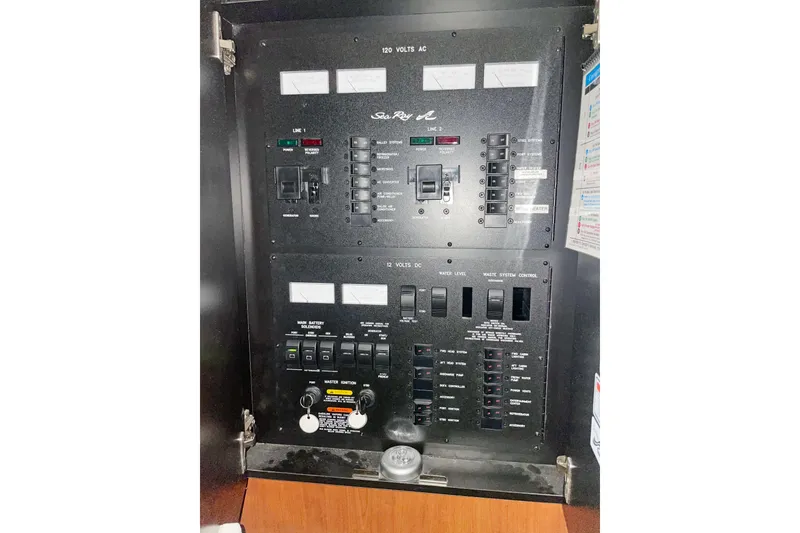 Slide: The Image of Electrical control panel of 2004 Sea Ray 380 Sundancer boat, featuring switches and meters. - 12
