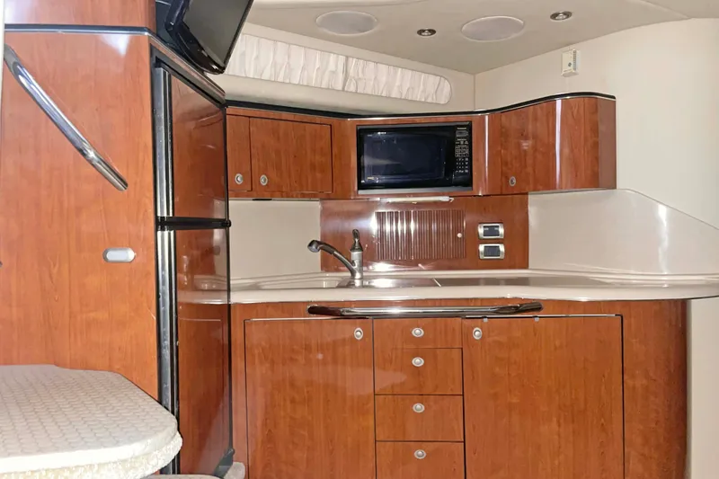 Slide: The Image of 2004 Sea Ray 380 Sundancer yacht interior kitchen with wood cabinetry and modern appliances. - 23