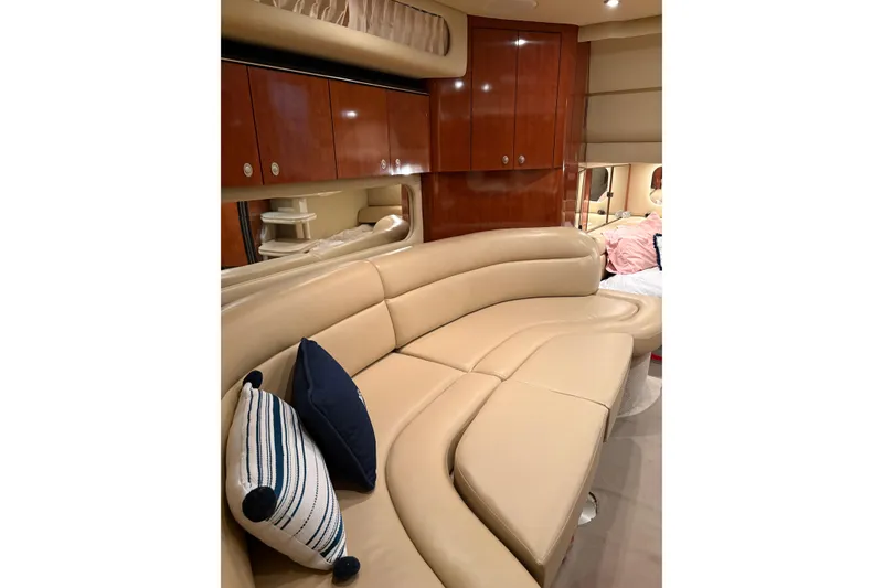 Slide: The Image of Luxurious interior of 2004 Sea Ray 380 Sundancer with beige leather seating and wooden cabinets. - 27
