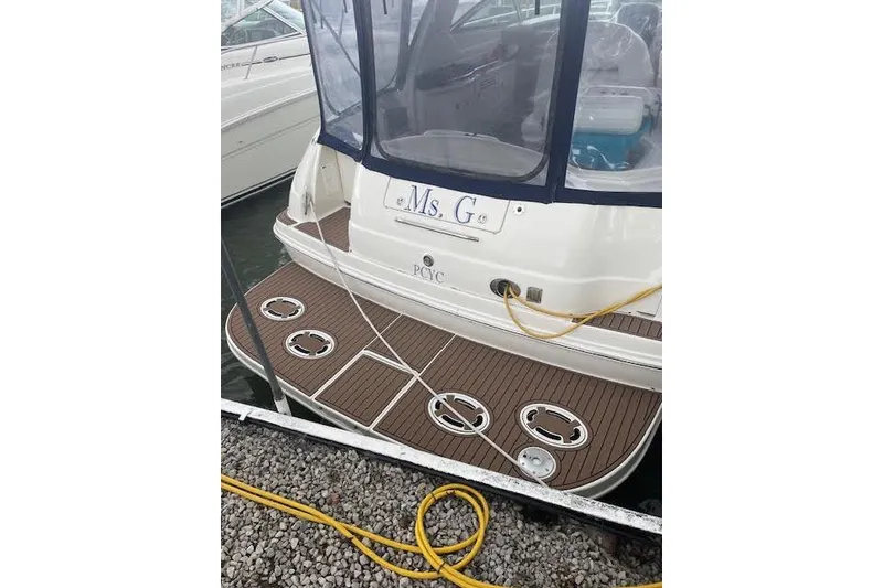 Slide: The Image of 2004 Sea Ray 380 Sundancer docked, featuring a wooden deck and covered seating area. - 3