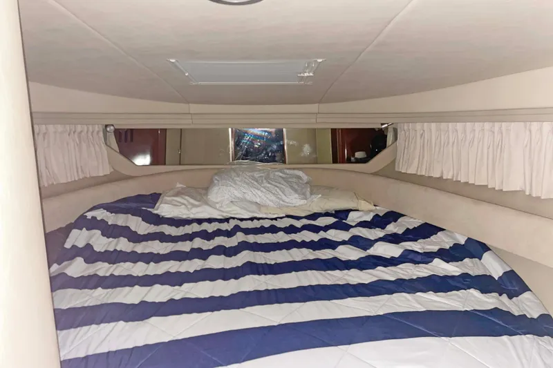 Slide: The Image of 2004 Sea Ray 380 Sundancer cabin with striped bedding and curtains. - 30