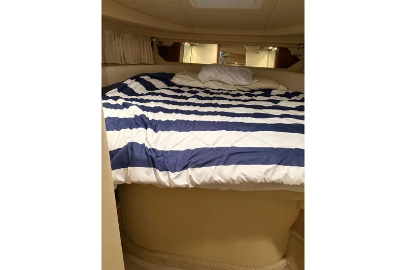 Slide: The Image of Cozy cabin interior of 2004 Sea Ray 380 Sundancer with striped bedding. - 31