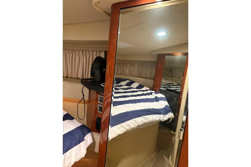 Slide: The Image of Interior cabin of 2004 Sea Ray 380 Sundancer with striped bedding and mirror. - 36
