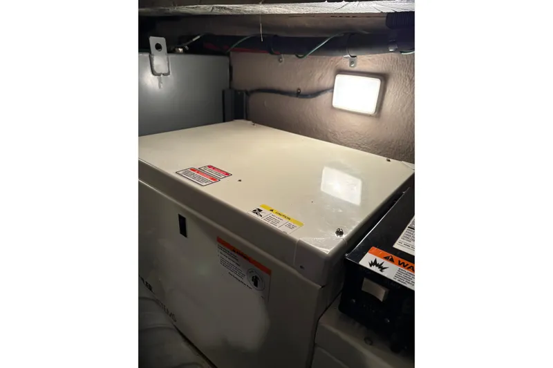 Slide: The Image of Engine compartment of a 2004 Sea Ray 380 Sundancer, featuring a generator and warning labels. - 41