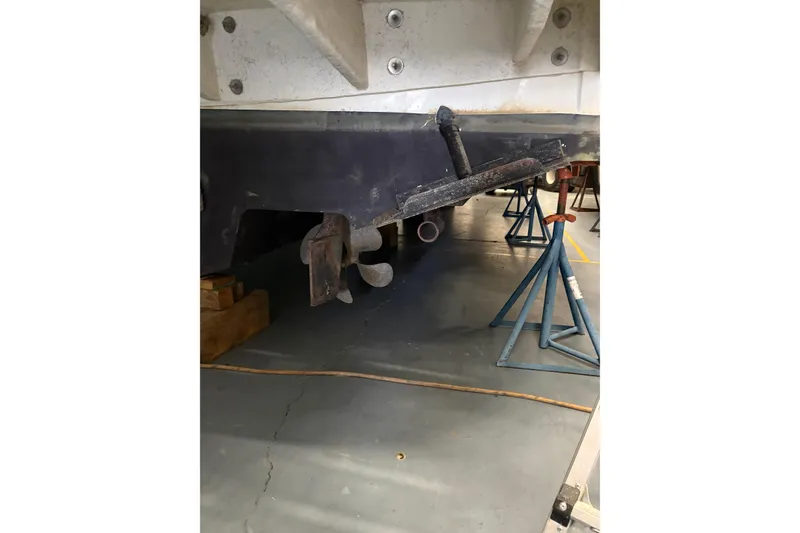 Slide: The Image of 2004 Sea Ray 380 Sundancer under maintenance, showing propeller and hull on stands. - 47