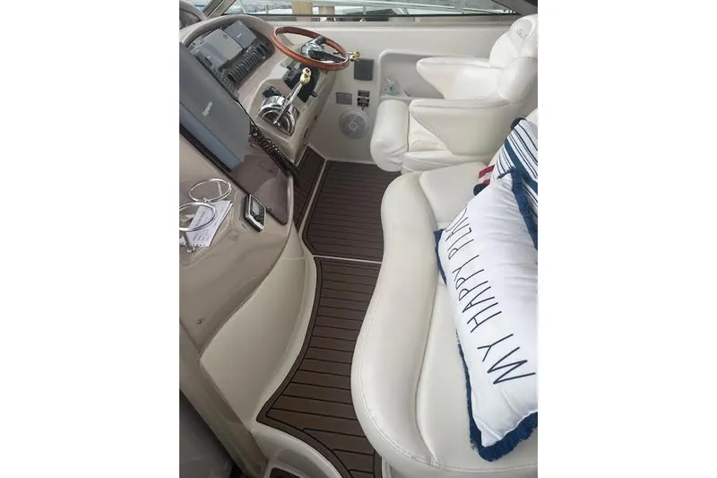 Slide: The Image of 2004 Sea Ray 380 Sundancer cockpit with white seating and wooden accents. - 5