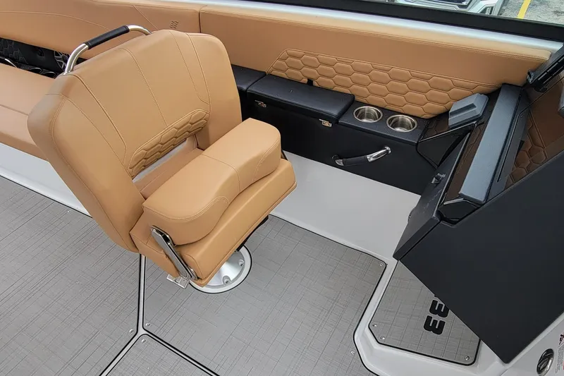 Slide: The Image of 2026 Four Winns H33 OB boat interior with tan seating and modern console design. - 11