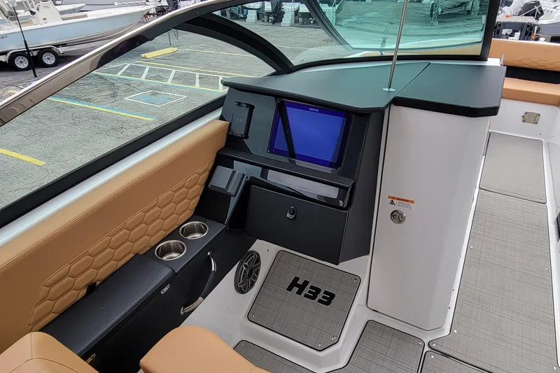 Slide: The Image of Interior of 2026 Four Winns H33 OB boat with modern dashboard and seating. - 12