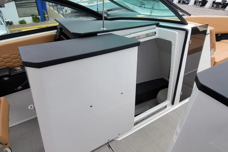 Slide: The Image of 2026 Four Winns H33 OB boat interior with open cabin door and seating area. - 16